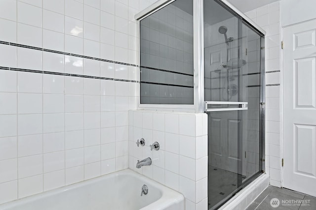 bathroom featuring a tub and tiled shower