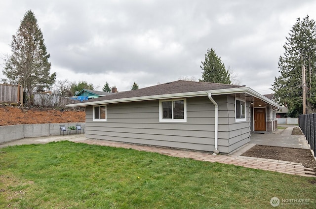 view of side of home with a chimney, a lawn, a patio area, and fence