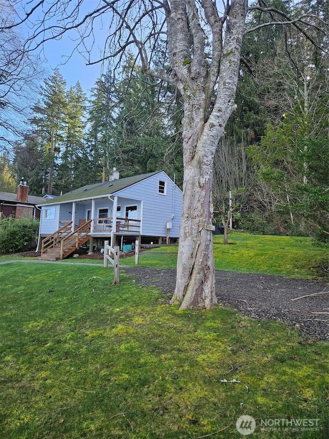 view of front of home featuring a front lawn and a wooden deck