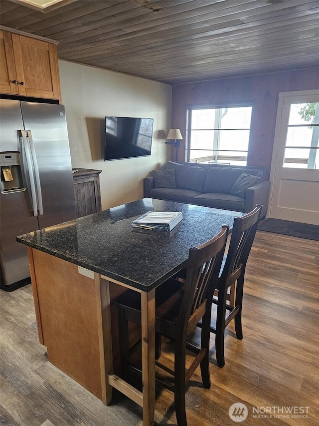 kitchen with wood ceiling, dark wood-style floors, stainless steel fridge, and brown cabinets