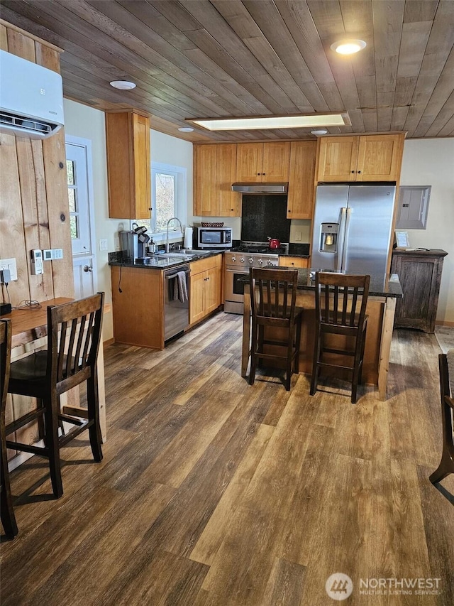 kitchen with stainless steel appliances, dark countertops, wood ceiling, a wall mounted air conditioner, and under cabinet range hood