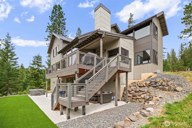 back of house featuring stairway, a patio area, board and batten siding, and a hot tub