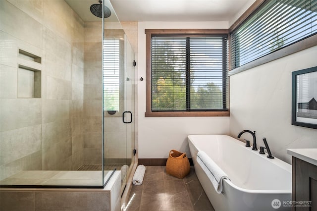 bathroom featuring a stall shower, a freestanding tub, and vanity