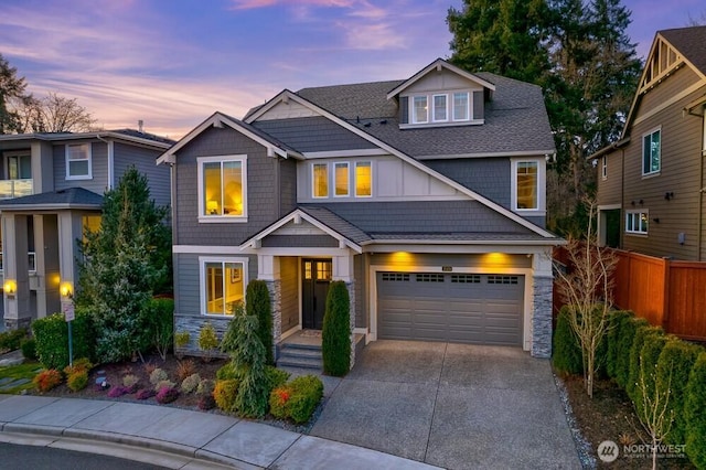 craftsman inspired home featuring driveway, stone siding, an attached garage, and fence