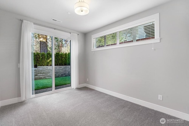 spare room with carpet floors, baseboards, and visible vents