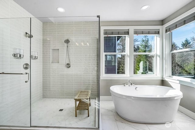 bathroom featuring a stall shower, baseboards, a soaking tub, marble finish floor, and recessed lighting