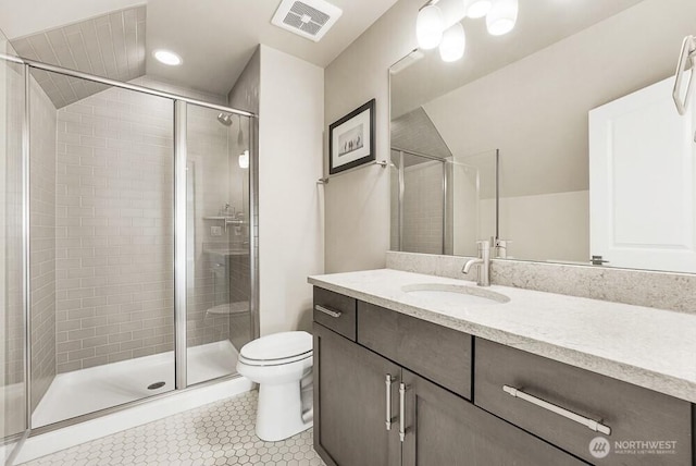 bathroom featuring toilet, a shower stall, visible vents, and tile patterned flooring