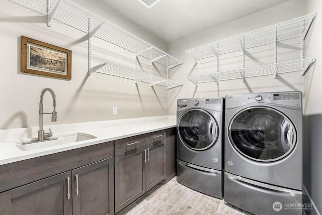 washroom with a sink, cabinet space, and washer and dryer