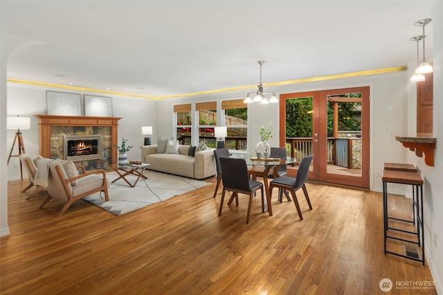 dining area featuring light wood-style flooring, a fireplace, and a healthy amount of sunlight