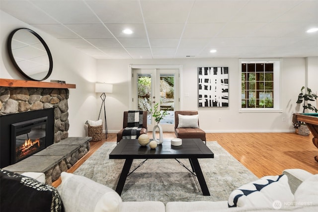 living area featuring recessed lighting, baseboards, wood finished floors, and a fireplace