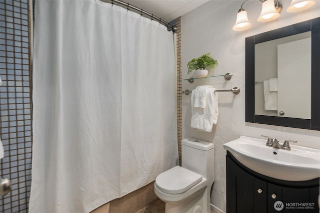 bathroom featuring curtained shower, toilet, and vanity