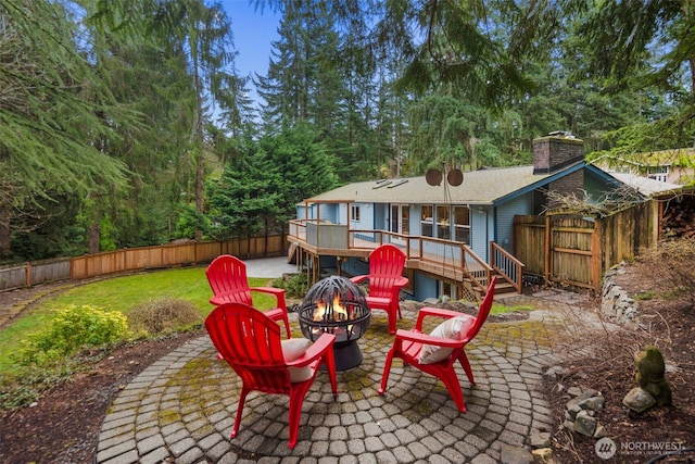 view of patio with a fire pit, a fenced backyard, and a wooden deck