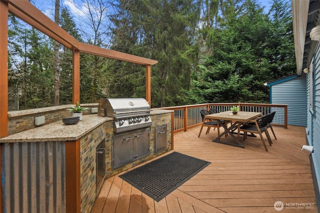 wooden deck featuring area for grilling, outdoor dining area, and a grill