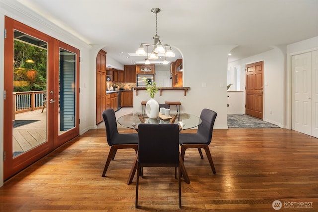 dining area featuring a notable chandelier, french doors, baseboards, and wood finished floors