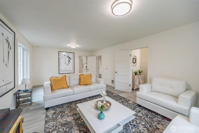 living room with baseboards and light wood-style floors