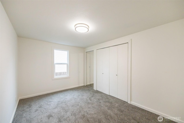 unfurnished bedroom with two closets, baseboards, and carpet