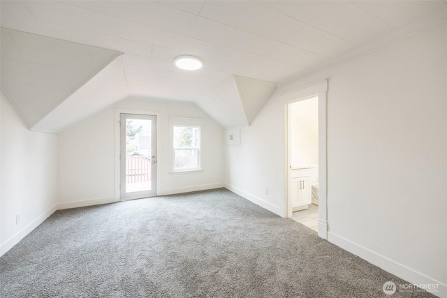 additional living space featuring vaulted ceiling, carpet flooring, and baseboards