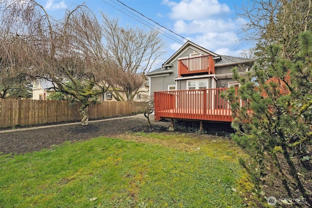 view of yard featuring a balcony and fence