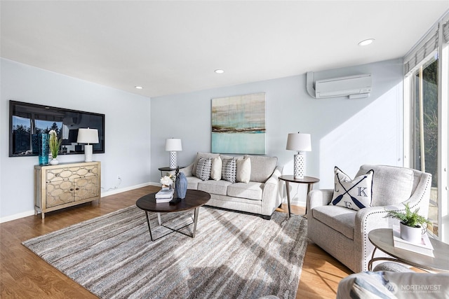 living room featuring recessed lighting, baseboards, a wall unit AC, and wood finished floors