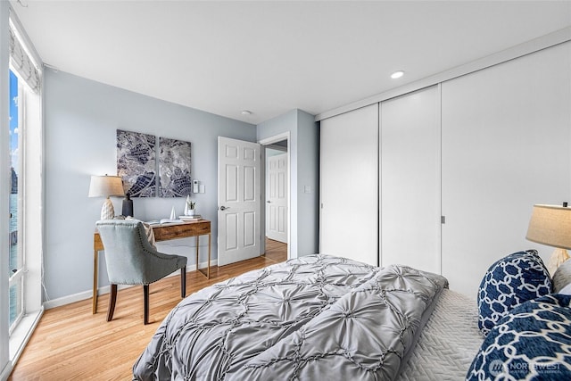 bedroom featuring a closet, light wood-type flooring, and baseboards