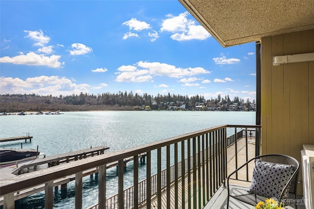 balcony with a boat dock and a water view