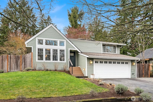 traditional home featuring aphalt driveway, a garage, fence, and a front lawn