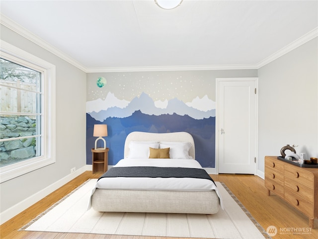 bedroom with an accent wall, ornamental molding, wood finished floors, and baseboards