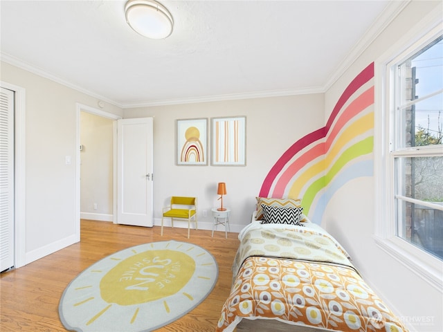 bedroom featuring ornamental molding, wood finished floors, and baseboards