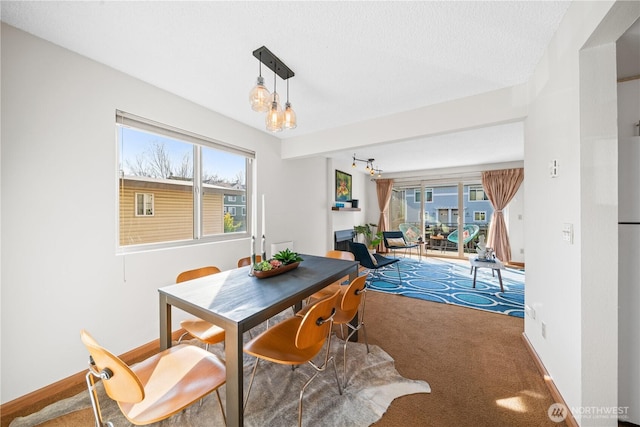 carpeted dining space with baseboards