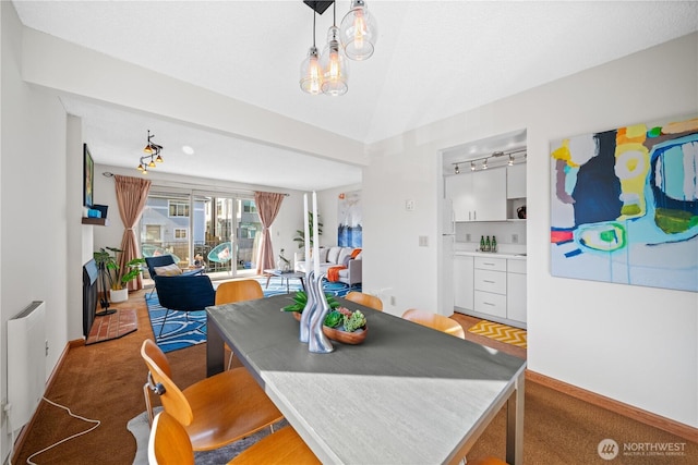 dining area featuring vaulted ceiling, light carpet, and baseboards