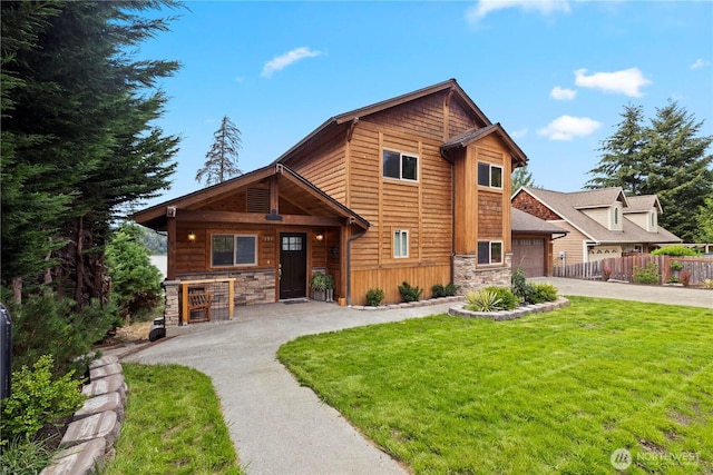 view of front of home with a garage, stone siding, aphalt driveway, fence, and a front yard