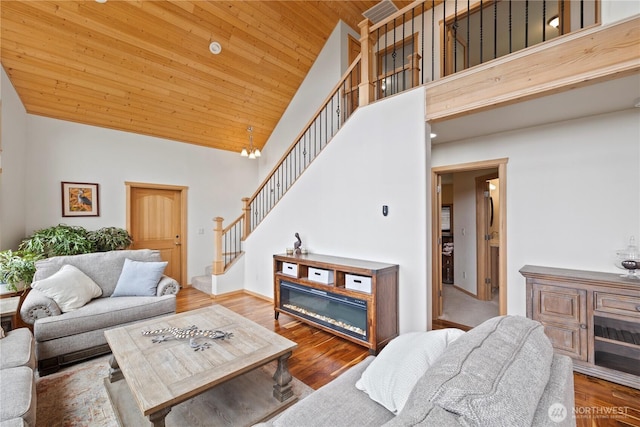 living area with wood ceiling, wood finished floors, stairs, high vaulted ceiling, and a notable chandelier