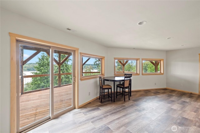 dining space with visible vents, light wood finished floors, and baseboards