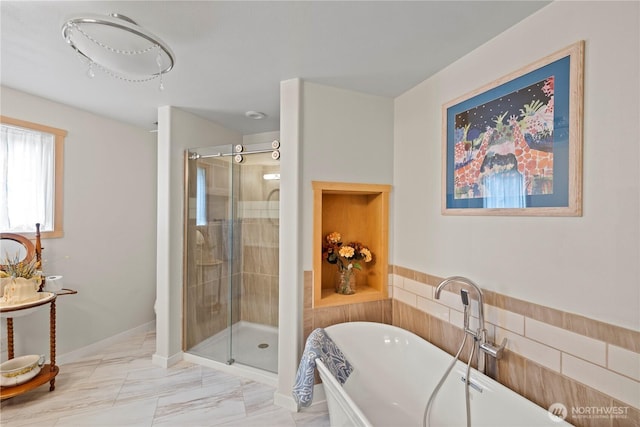 bathroom with a freestanding bath, marble finish floor, and a shower stall