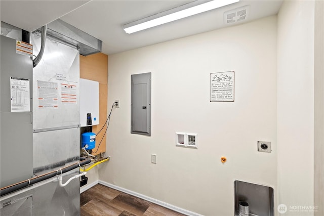 utility room featuring electric panel, visible vents, and heating unit