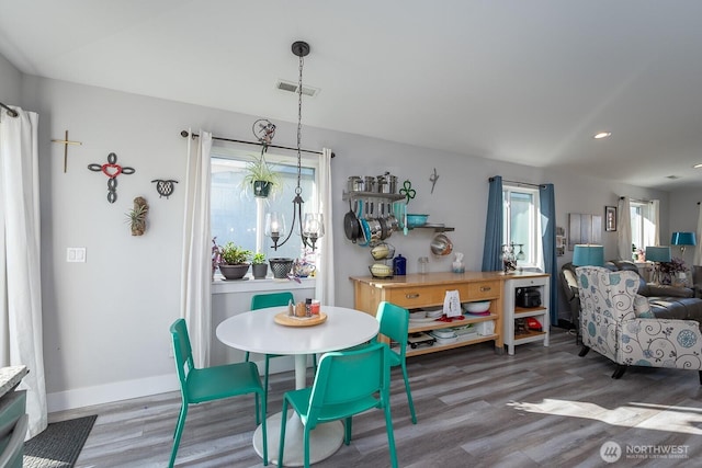 dining room featuring visible vents, baseboards, and wood finished floors