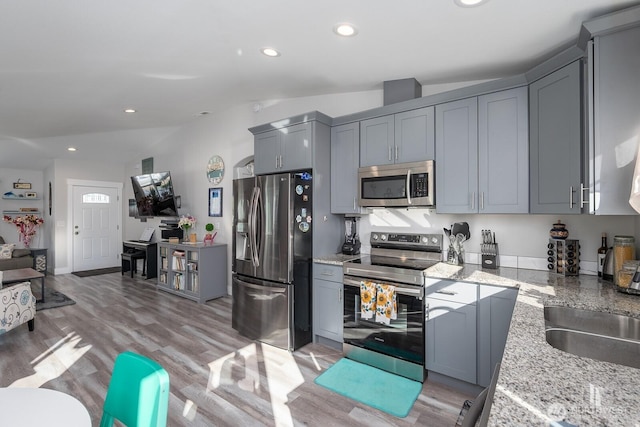 kitchen featuring recessed lighting, light wood-style flooring, appliances with stainless steel finishes, and gray cabinetry