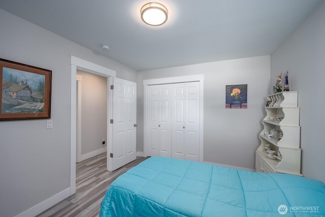 bedroom with baseboards, a closet, and wood finished floors