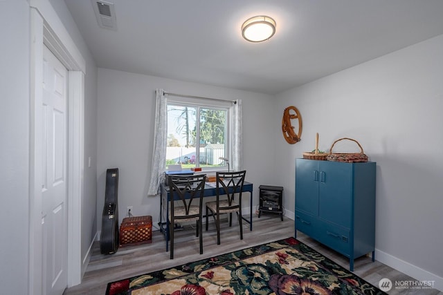 dining space featuring light wood-style floors, visible vents, and baseboards