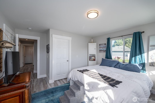 bedroom with wood finished floors and baseboards