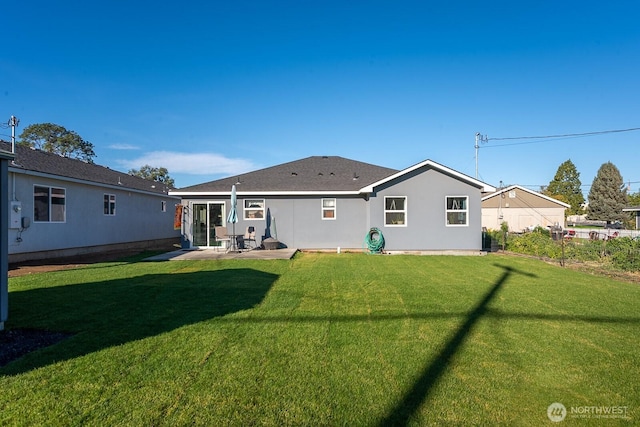 rear view of house with a yard, a patio, and stucco siding