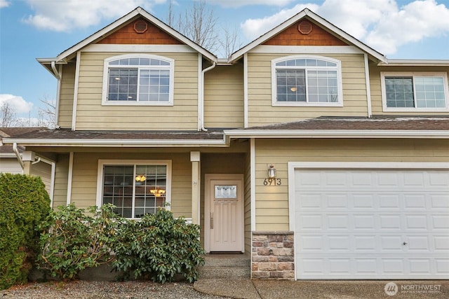 view of front facade featuring a garage, stone siding, and roof with shingles