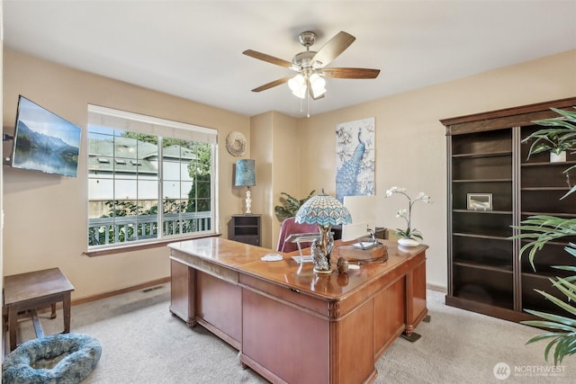 office area with visible vents, light colored carpet, baseboards, and ceiling fan