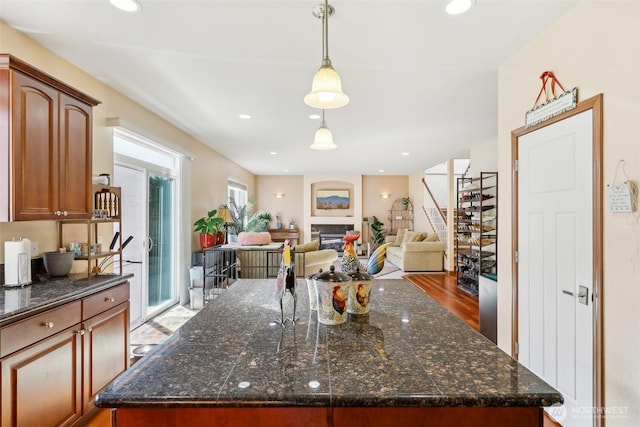 kitchen with a glass covered fireplace, decorative light fixtures, recessed lighting, and a kitchen island