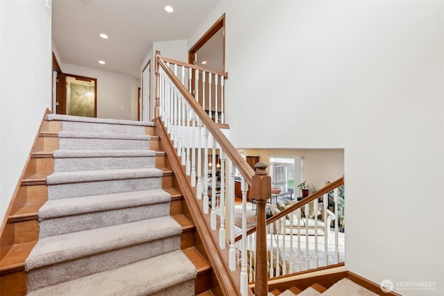 staircase with recessed lighting and a high ceiling