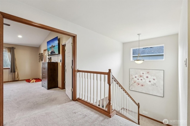 corridor with an upstairs landing, baseboards, and carpet floors