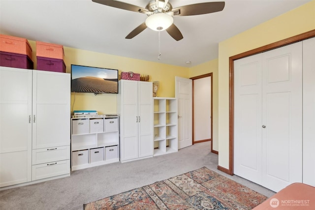 unfurnished bedroom with a closet, light carpet, baseboards, and ceiling fan