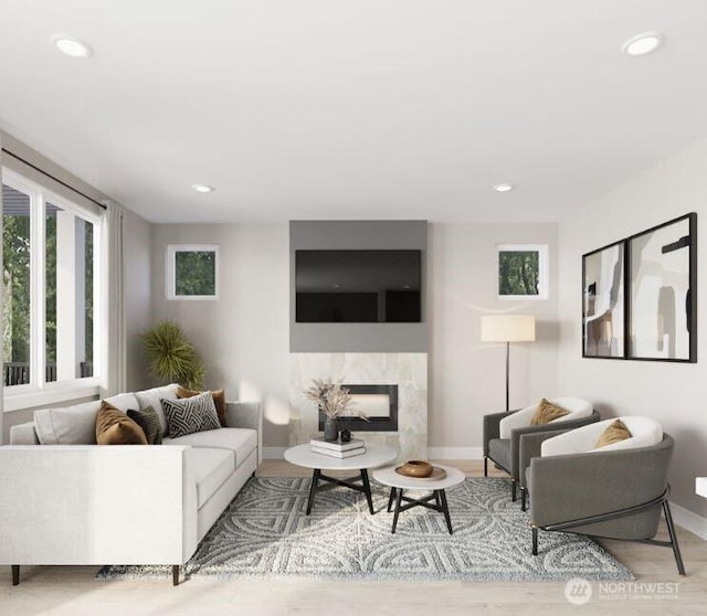 living room featuring recessed lighting, wood finished floors, baseboards, and a premium fireplace