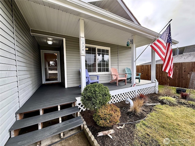 property entrance featuring a porch and fence