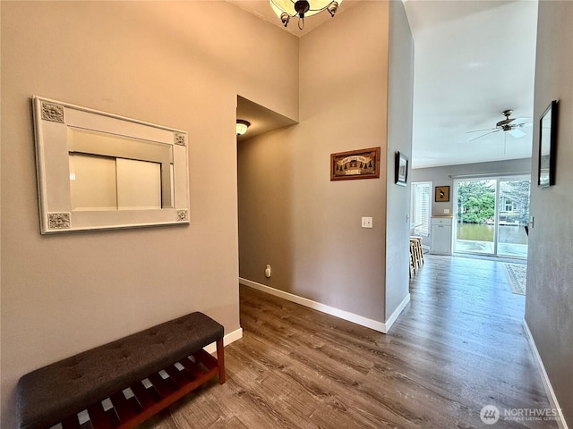 corridor with wood finished floors and baseboards